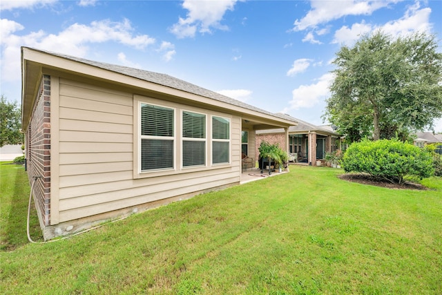 back of house featuring a patio area and a lawn