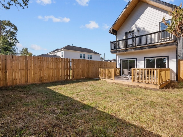 back of property with a lawn, a balcony, and a patio area