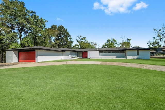 ranch-style house featuring a garage and a front lawn