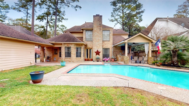 view of pool with a yard, a patio area, ceiling fan, and a bar