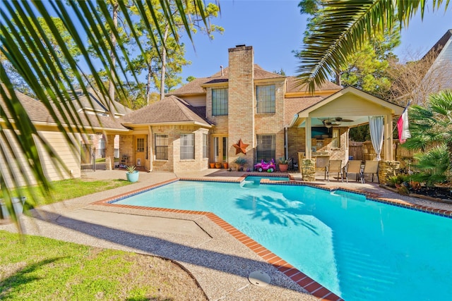 view of pool with a bar, a patio, and ceiling fan