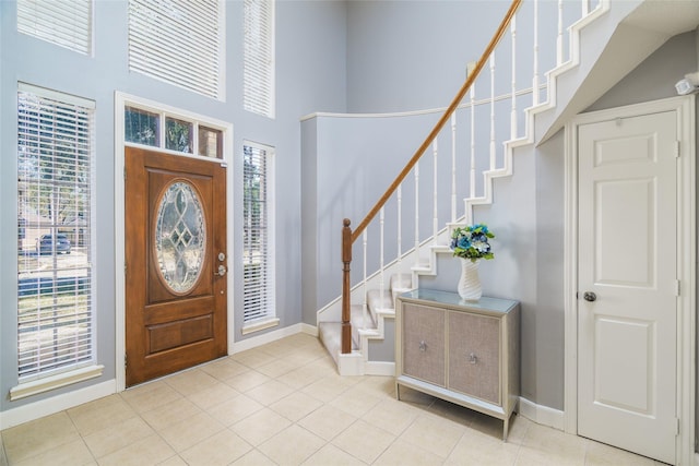 foyer featuring a high ceiling, light tile patterned flooring, and a wealth of natural light