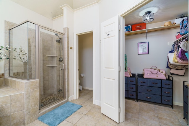 bathroom featuring toilet, tile patterned floors, and a shower with shower door