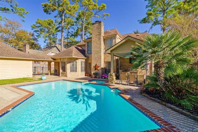 view of swimming pool with a patio, exterior bar, and ceiling fan