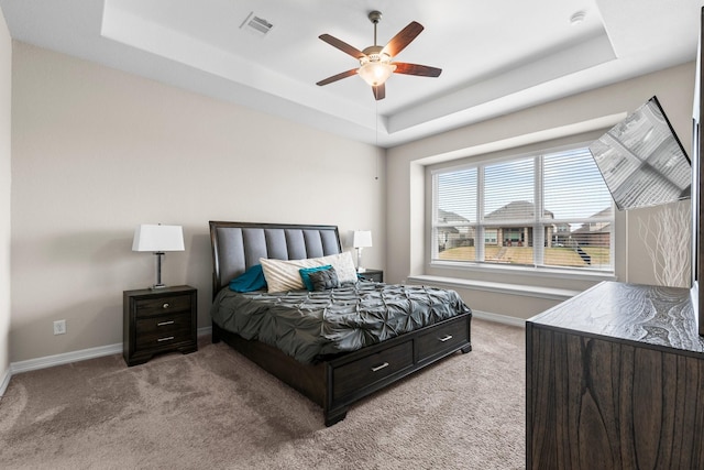 bedroom featuring a tray ceiling, carpet floors, and ceiling fan