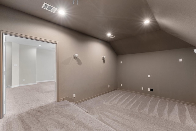 unfurnished room featuring light colored carpet and vaulted ceiling