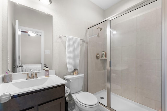 bathroom featuring toilet, vanity, and walk in shower