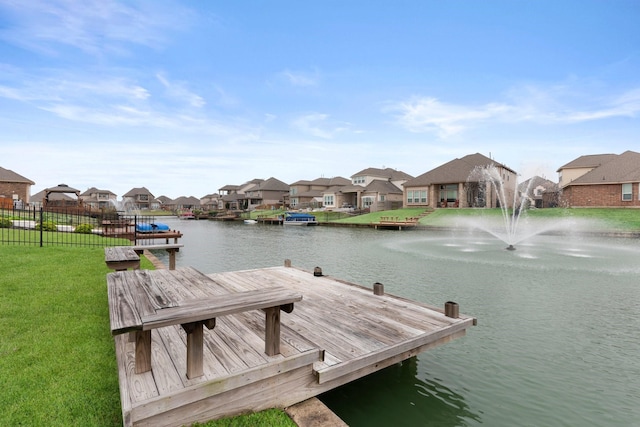 dock area with a lawn and a water view