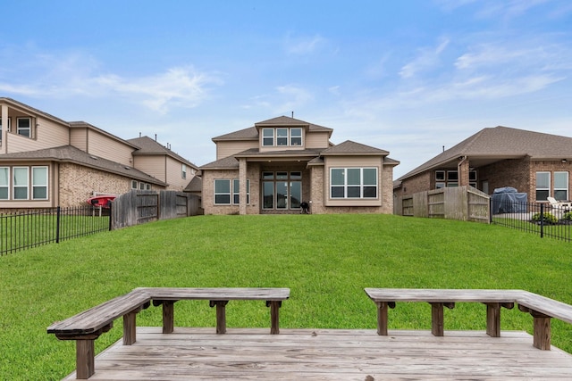 back of house featuring a wooden deck and a yard