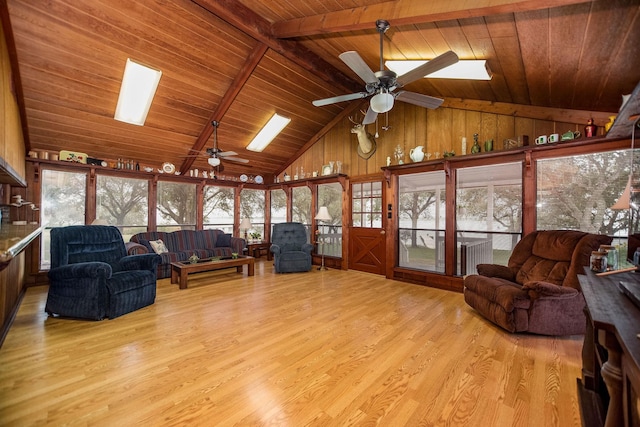 living room with wood ceiling, a skylight, light hardwood / wood-style floors, and beamed ceiling