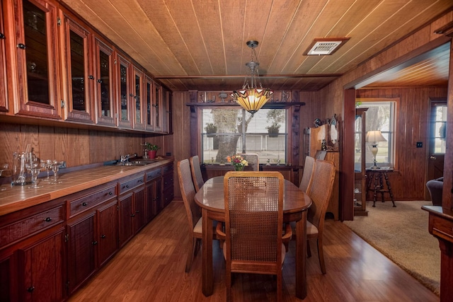 dining area with wood ceiling, light hardwood / wood-style flooring, and wood walls