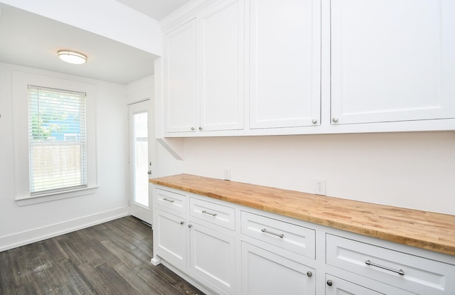 kitchen featuring white cabinetry, dark wood-type flooring, and butcher block counters