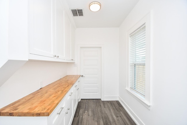 bar with dark hardwood / wood-style flooring, white cabinets, and wood counters