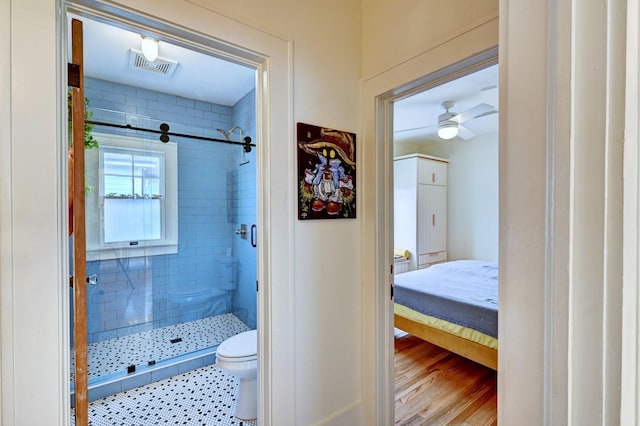 bathroom with ceiling fan, tiled shower, and toilet