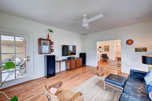 living room with light hardwood / wood-style floors and ceiling fan