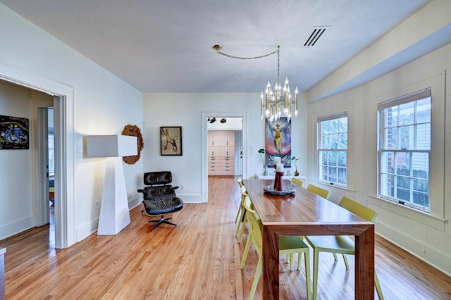 dining area with an inviting chandelier and light wood-type flooring