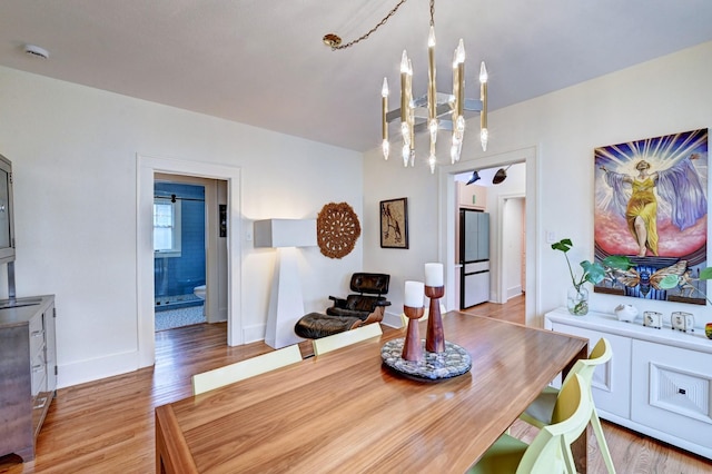 dining room with hardwood / wood-style flooring and an inviting chandelier