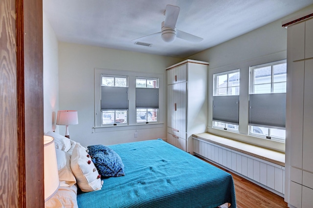 bedroom featuring ceiling fan, radiator, and light wood-type flooring