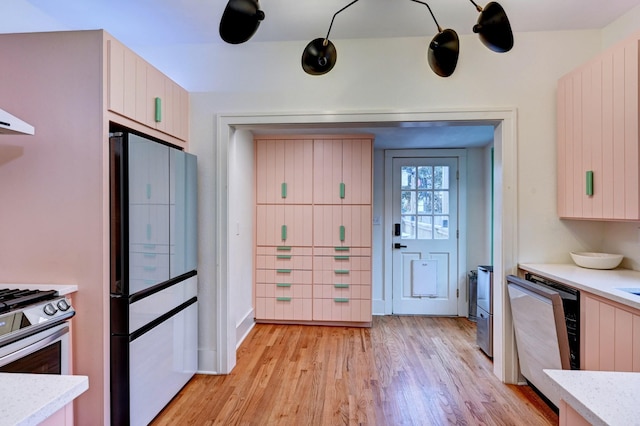 kitchen featuring dishwashing machine, stainless steel range with gas stovetop, refrigerator, and light wood-type flooring