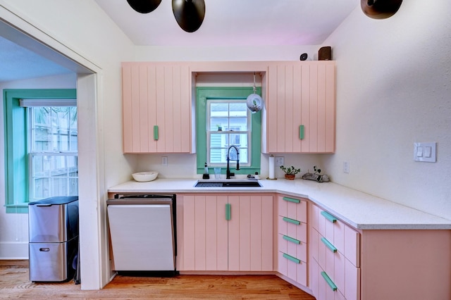 kitchen featuring ceiling fan, sink, dishwashing machine, and light hardwood / wood-style floors