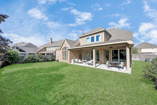 rear view of property featuring a lawn and a patio