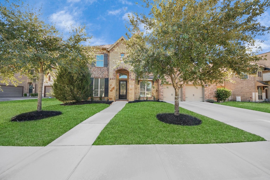 view of front of house featuring a garage and a front lawn