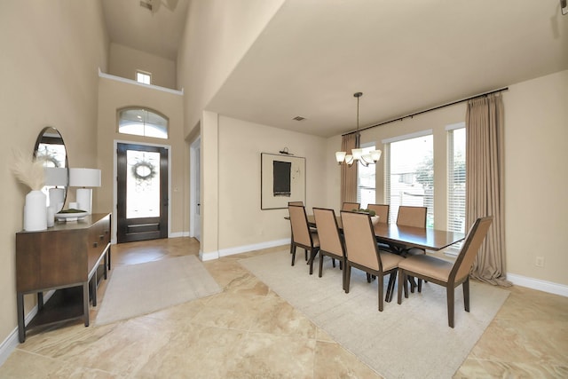 dining space featuring a high ceiling and a notable chandelier