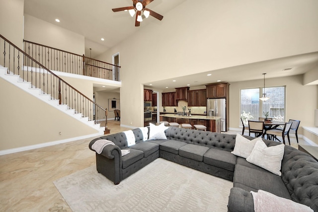 living room with a towering ceiling and ceiling fan