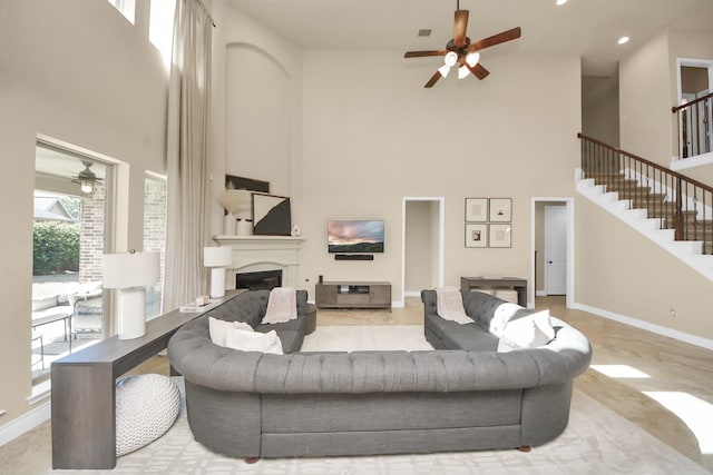 living room with ceiling fan and a high ceiling