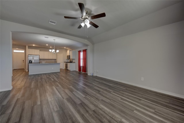 unfurnished living room with hardwood / wood-style flooring, lofted ceiling, and ceiling fan with notable chandelier