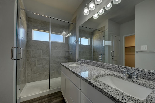 bathroom featuring a shower with door, vanity, and wood-type flooring