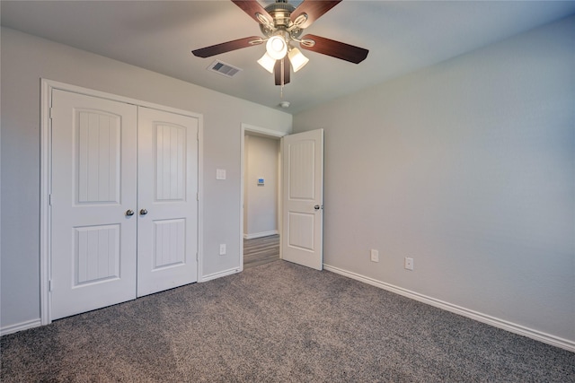 unfurnished bedroom featuring dark carpet, a closet, and ceiling fan