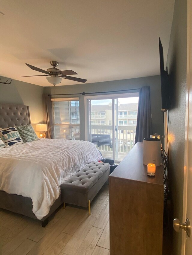 bedroom featuring light hardwood / wood-style flooring, ceiling fan, and access to outside