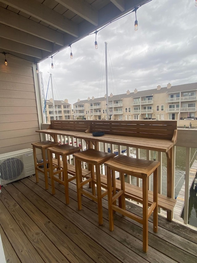 wooden deck with ac unit and an outdoor bar