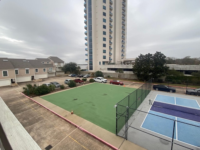 view of home's community featuring tennis court