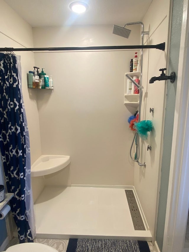 bathroom featuring toilet and walk in shower