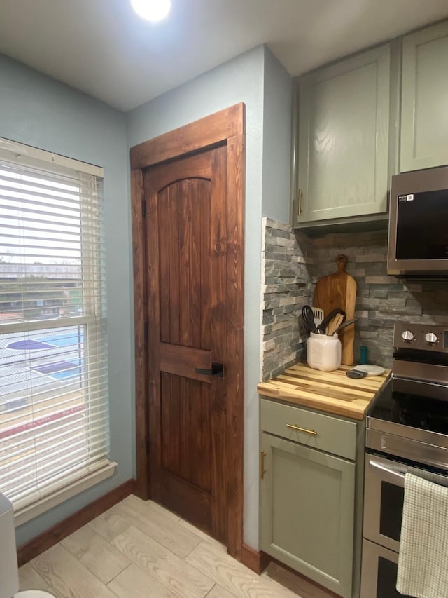 kitchen featuring wood counters, backsplash, and stainless steel appliances