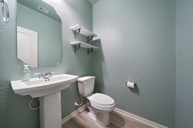 bathroom featuring sink, toilet, and hardwood / wood-style floors