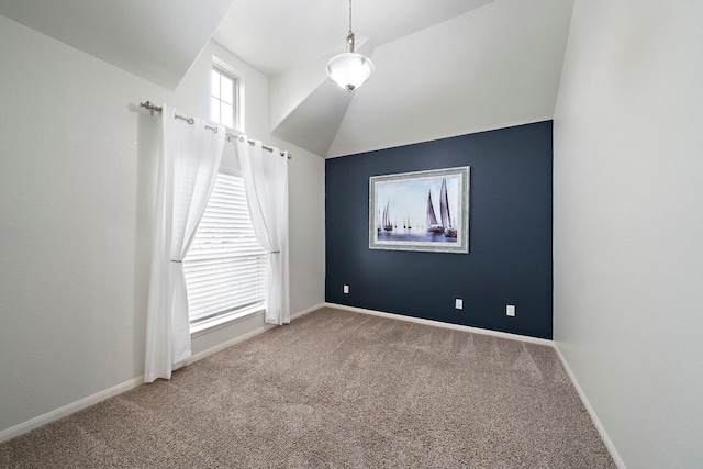 carpeted empty room with vaulted ceiling