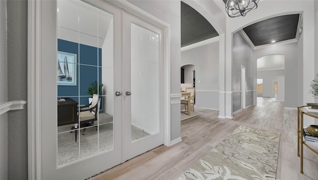 entryway with ornamental molding and light wood-type flooring