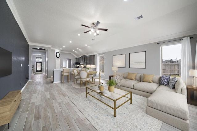 living room with crown molding, light hardwood / wood-style flooring, ceiling fan, and plenty of natural light