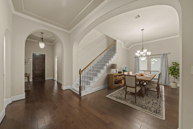 dining room featuring dark hardwood / wood-style flooring, ornamental molding, and an inviting chandelier