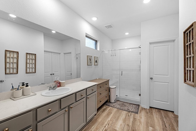 bathroom featuring an enclosed shower, wood-type flooring, and vanity