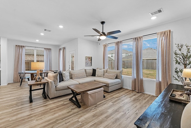 living room with ceiling fan and light hardwood / wood-style flooring