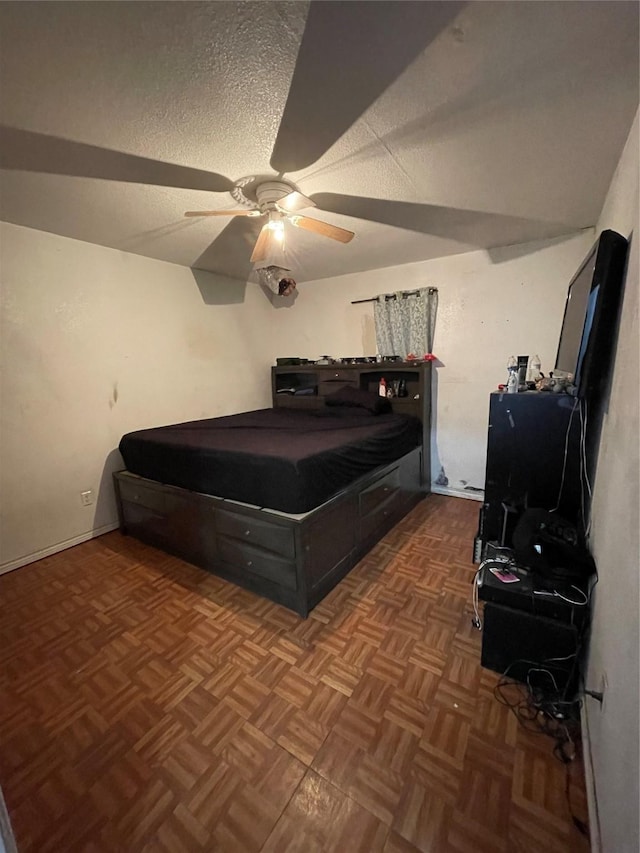 bedroom featuring ceiling fan, dark parquet floors, and a textured ceiling