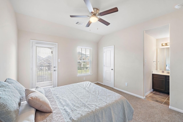 carpeted bedroom with ceiling fan, lofted ceiling, and ensuite bathroom