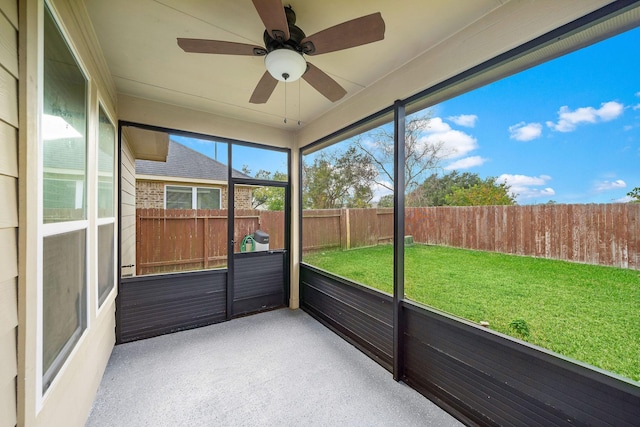 unfurnished sunroom featuring ceiling fan