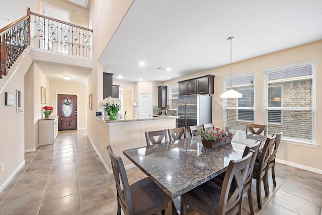 tiled dining space featuring a high ceiling