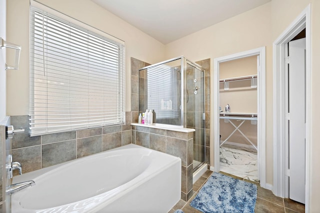 bathroom featuring tile patterned flooring and separate shower and tub