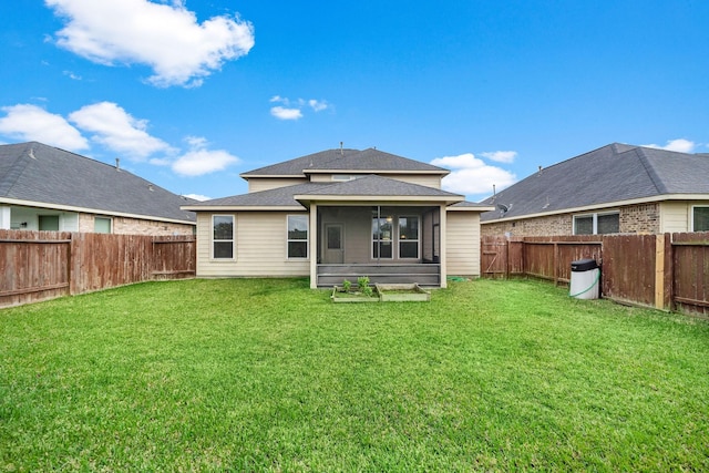 rear view of house with a yard and a sunroom